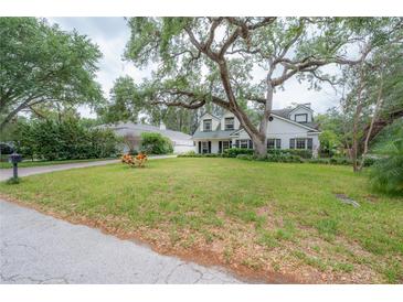 Charming two-story home with a lush green lawn and mature trees in a desirable neighborhood at 2305 S Hesperides St, Tampa, FL 33629