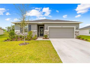 Charming single-Gathering home features stone accents, lush landscaping, and a welcoming two-car garage at 37587 Mackenzie Dr, Zephyrhills, FL 33540