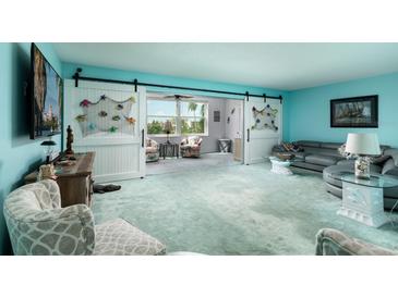 Spacious living room with sliding barn doors and coastal decor, offering a relaxing atmosphere at 5575 Gulf Blvd # 421, St Pete Beach, FL 33706