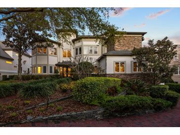 Inviting front yard with mature trees, shrubs, and a brick path leading to the front door at 1058 Roundstone Pl, Palm Harbor, FL 34683