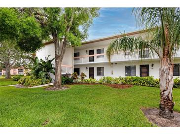 Inviting condo exterior with manicured lawn and tropical landscaping at 129 Lakeview Way, Oldsmar, FL 34677