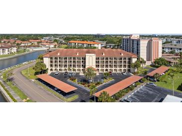 Stunning aerial view of the condo building featuring covered parking and lovely landscaping near the water at 19029 Us Highway 19 N # 26-204, Clearwater, FL 33764