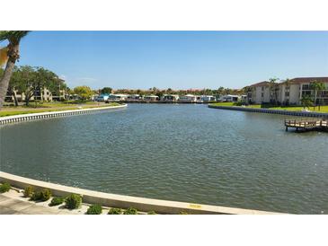 Scenic water view overlooking a canal with lush landscaping and buildings on both sides under a clear blue sky at 19029 Us Highway 19 N # 8-13, Clearwater, FL 33764