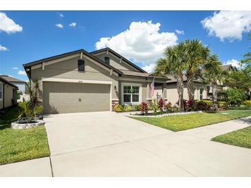 Well-maintained home boasts a two-car garage, neat landscaping, and a spacious concrete driveway at 6477 Dutton Dr, Wesley Chapel, FL 33545