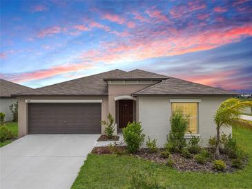 Charming single-story home featuring a two-car garage, landscaped front yard, and a covered entryway at 8598 Parsons Hill Blvd, Wesley Chapel, FL 33545