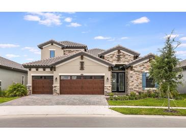 Stunning two-story home featuring a stone facade, three-car garage, and manicured front lawn at 11146 Rustic Timber Loop, San Antonio, FL 33576