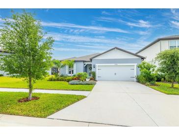 Charming one-story home featuring a two-car garage, beautifully landscaped front yard, and a well-maintained lawn at 12916 Brookside Moss Dr, Riverview, FL 33579