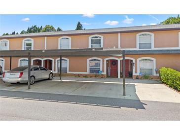 Charming townhome with covered parking and well-maintained landscaping enhances curb appeal at 14910 Par Club Cir, Tampa, FL 33618