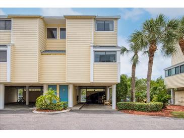 Charming two-story townhouse with tropical landscaping and covered parking at 1500 Sunset Rd # F8, Tarpon Springs, FL 34689