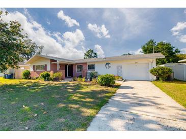 Charming single-story home featuring a brick facade, well-manicured lawn, and a two-car garage at 2030 Magnolia Dr, Clearwater, FL 33764
