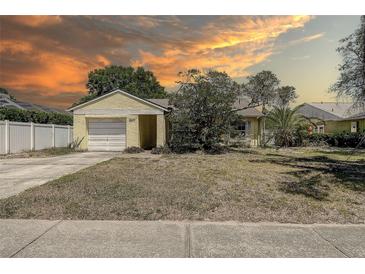 Charming single-story home with attached garage and mature trees in a quiet neighborhood at 3647 Lake St George Dr, Palm Harbor, FL 34684