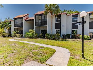 Inviting exterior of a condominium featuring well-maintained landscaping and a charming walkway leading to the entrance at 3281 Beneva Rd # 202, Sarasota, FL 34232