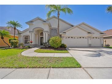 Charming single-story home featuring a lush front yard and a three-car garage at 7001 Cohasset Cir, Riverview, FL 33578