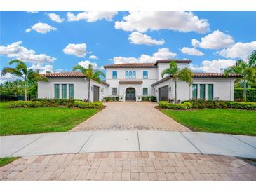 Stately two-story home with lush landscaping, a paver driveway, and a tile roof at 16419 Chapman Crossing Dr, Lithia, FL 33547