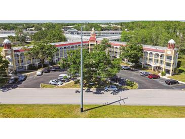 Aerial view of multi-story building, parking lot, and surrounding landscaped grounds at 2430 Florentine Way # 46, Clearwater, FL 33763