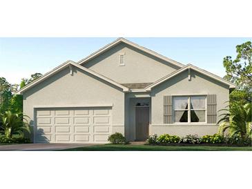 Charming single-story home featuring a two-car garage and landscaped front yard at 35687 Lockman Way, Zephyrhills, FL 33541