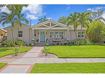 Well-maintained home featuring a freshly cut lawn, complemented by flourishing tropical plants and palm trees at 636 16Th Ne Ave, St Petersburg, FL 33704
