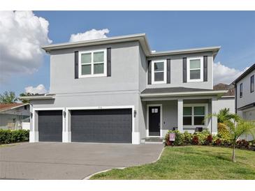 Beautiful two-story home with a two-car garage, dark shutters and well-manicured landscaping at 714 S Lois Ave, Tampa, FL 33609