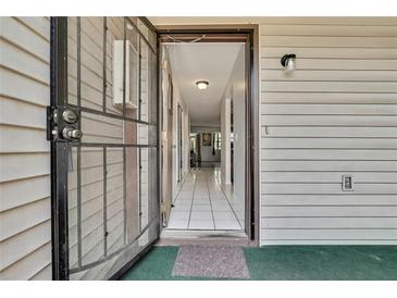 View of the doorway leading into the home with tiled flooring and a storm door at 12155 Environmental Dr # 3, New Port Richey, FL 34654