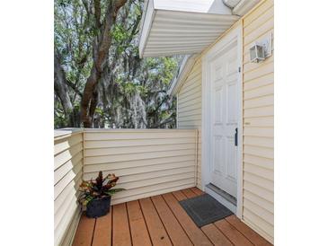 Inviting front door entrance with covered wooden porch, a potted plant, and exterior light fixture at 130 Sabal Ct # C, Oldsmar, FL 34677