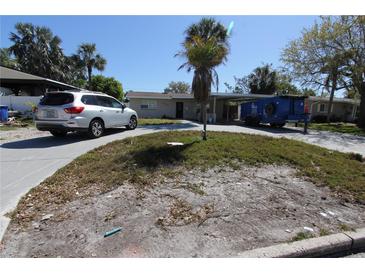 Charming single-story home featuring a carport, driveway, and landscaped front yard with a mature palm tree at 4327 Huntington Ne St, St Petersburg, FL 33703