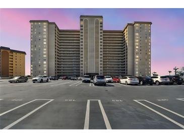 A large apartment building with multiple floors stands above a parking lot filled with parked cars at 5200 Brittany S Dr # 1502, St Petersburg, FL 33715