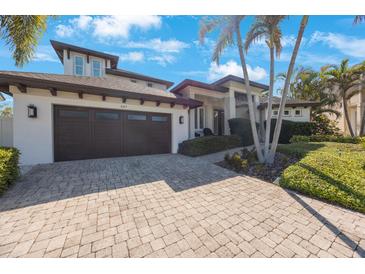 Stunning two-story home with a 2-car garage and a beautifully paved driveway lined with lush tropical landscaping at 597 Bay St, Palm Harbor, FL 34683
