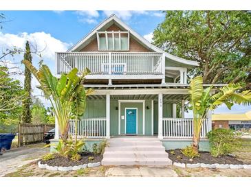 Charming two-story home featuring a large front porch, balcony, and a brightly colored front door at 105 W Columbus Dr, Tampa, FL 33602
