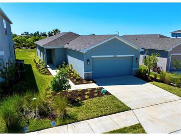 Charming single-story home with a well-manicured lawn and a two-car garage, showcasing its inviting curb appeal at 11268 Fieldstone Dr, Palmetto, FL 34221