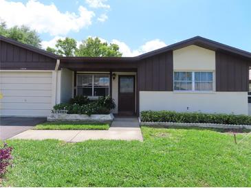 Charming single-story home with a well-maintained lawn and manicured landscaping at 1395 Heather Ridge Blvd, Dunedin, FL 34698