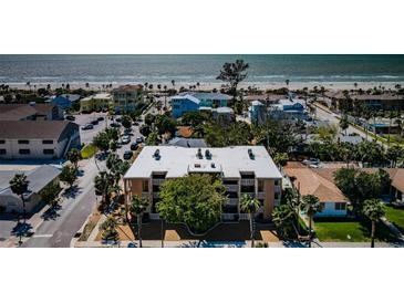 Aerial view of a beachfront apartment complex with palm trees lining the sandy beach at 1700 Pass A Grille Way # 9, St Pete Beach, FL 33706
