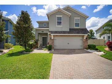 Charming two-story home featuring a gray exterior, brick accents, and a well-manicured front yard at 19278 Roseate Dr, Lutz, FL 33558