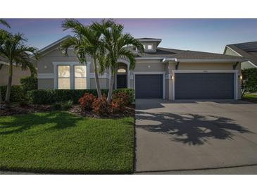 Charming single-story home with a well-manicured lawn, lush landscaping, and a spacious two-car garage at 6326 Waves End Pl, Apollo Beach, FL 33572