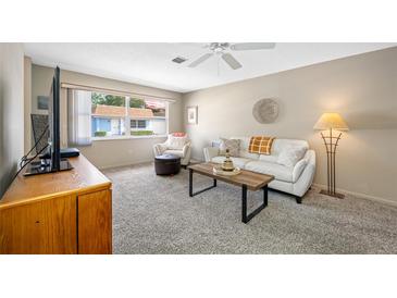 Cozy living room with a large window providing natural light, paired with white furniture and decor at 6920 Lafayette N # 6920, Pinellas Park, FL 33781