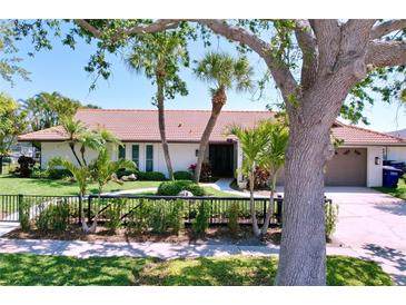 Front exterior of home with well-manicured landscaping and a tile roof at 773 Snug Is, Clearwater Beach, FL 33767