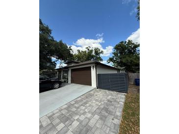 Charming single-story home featuring neutral paint, a brown garage door, and a stylish driveway at 2917 W Fern St, Tampa, FL 33612