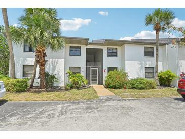 Well-maintained two-story condo with stucco exterior and landscaped grounds with mature palms at 2427 Twin Dr # 2, Sarasota, FL 34234