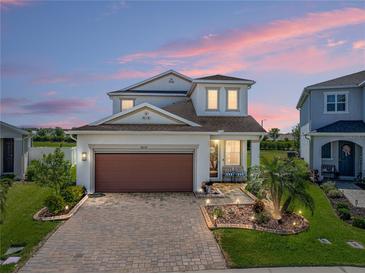 Beautiful two-story home featuring a brick paved driveway and a well-manicured lawn at 34135 White Fountain Ct, Wesley Chapel, FL 33545