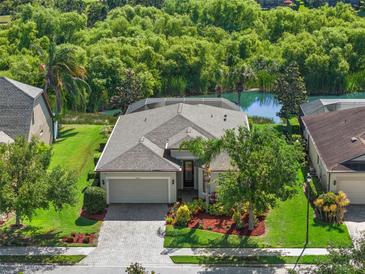 Aerial view of home with mature landscaping, pool, and water view at 4826 68Th Street E Cir, Bradenton, FL 34203