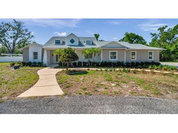 Charming home featuring a landscaped front yard, curved walkway, and a light gray exterior paint at 806 Linwood Ter, Lutz, FL 33549