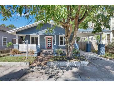 Charming bungalow-style home with blue siding, a red front door, and a covered carport at 2920 N 11Th St, Tampa, FL 33605