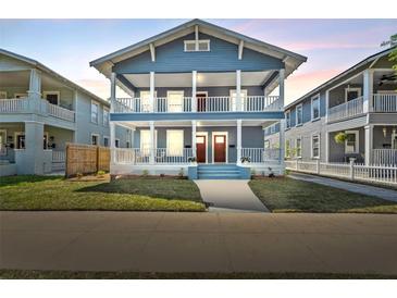 Charming blue two-story home featuring double porches, white columns, and lush green lawn at 307 S Newport Ave, Tampa, FL 33606
