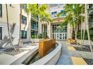 Modern building entrance featuring palm trees, a water feature, and glass doors at 400 4Th S Ave # 401, St Petersburg, FL 33701