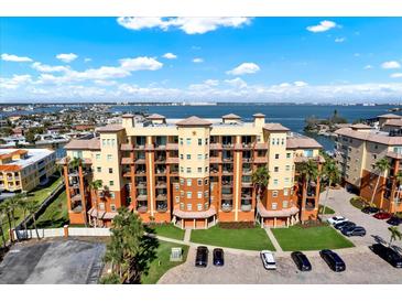 Beautiful condo building overlooking the water featuring balconies and palm trees at 5301 Gulf Blvd # B508, St Pete Beach, FL 33706
