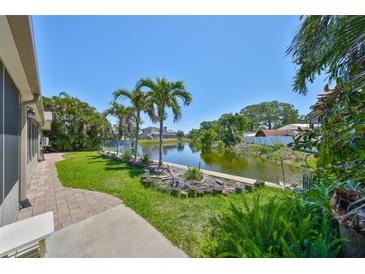 Spacious backyard with lush greenery and a beautiful pond view, enhancing the outdoor living experience at 5785 Bay Pines Lakes Blvd, St Petersburg, FL 33708