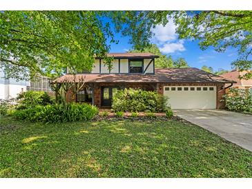Charming two-story home featuring a brick facade, manicured lawn, and attached two-car garage at 7902 River Ridge Dr, Temple Terrace, FL 33637