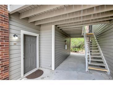 Condo entrance with gray door, gray siding, and white trim; exterior staircase to units above at 1400 Gandy N Blvd # 1701, St Petersburg, FL 33702