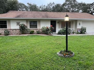Charming single-story home with a well-maintained lawn, complemented by a classic exterior lighting fixture at 1991 63Rd N Ave, St Petersburg, FL 33702