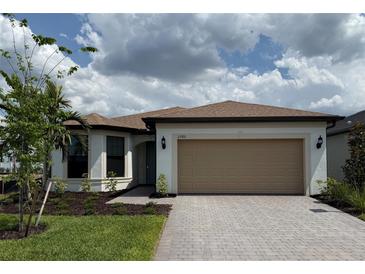 Charming single-story home with a two-car garage and paver driveway surrounded by a beautiful landscaped yard at 2760 Winding Creek Trl, North Port, FL 34289
