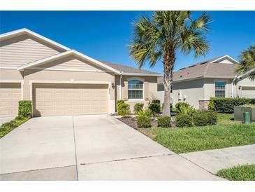 Charming single-Gathering home showcasing a well-maintained lawn and a two-car garage at 7869 Timberview Loop, Wesley Chapel, FL 33545